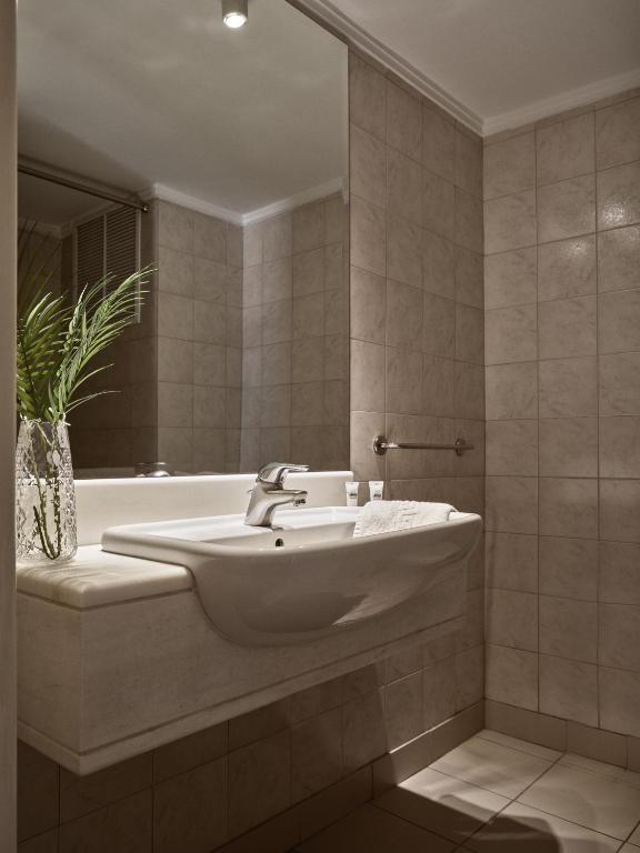 a bathroom with a sink and a bath tub at Strada Marina Hotel in Zakynthos