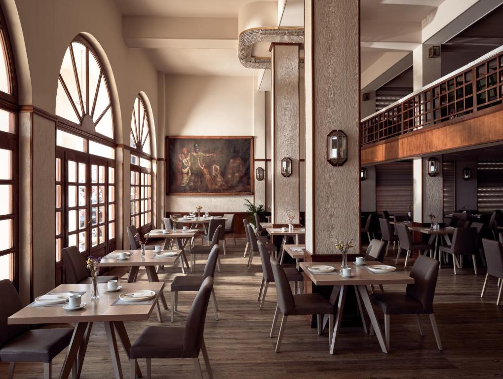 a restaurant with tables and chairs and windows at Strada Marina Hotel in Zakynthos