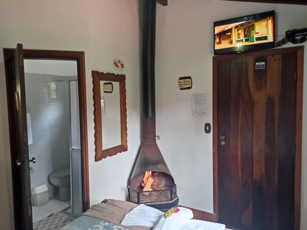 a room with a fireplace in the corner of a room at Pousada Alpenblumen in Monte Verde