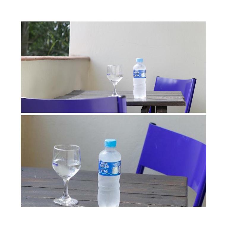 a bottle of water and two glasses on a table at Hotel Ibiá in Montenegro