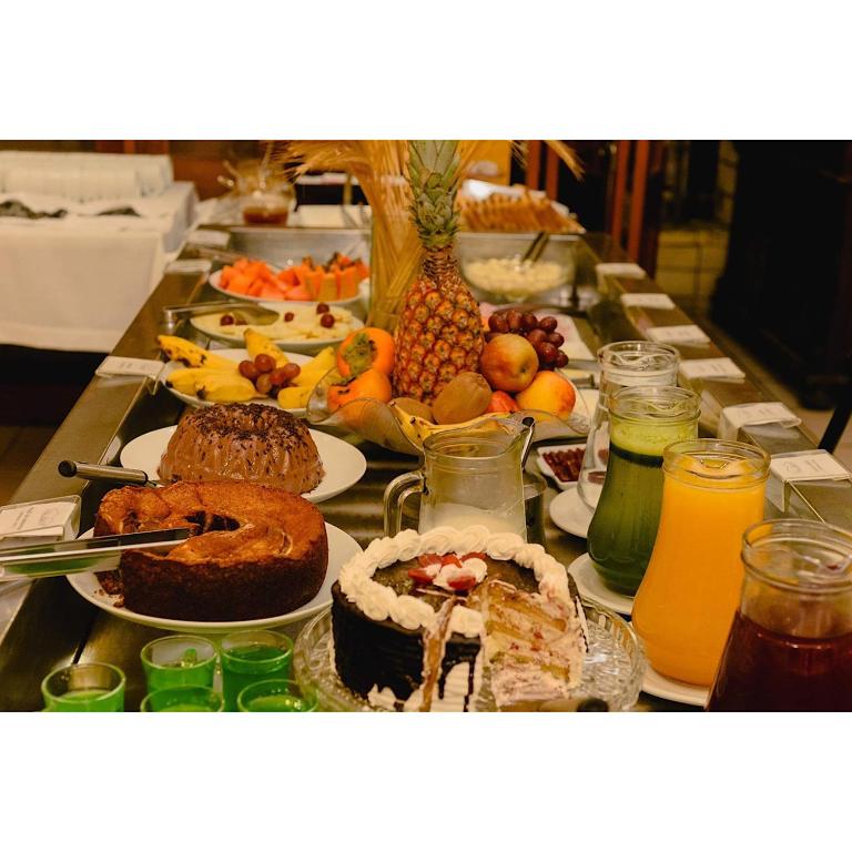 a table with many different types of food on it at Hotel Ibiá in Montenegro