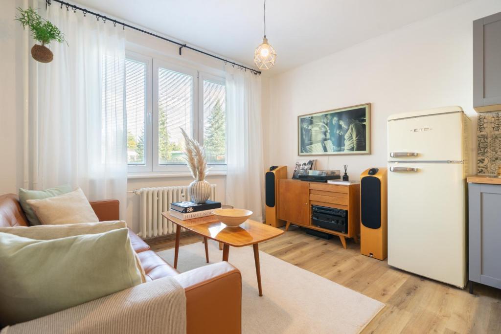 a living room with a couch and a refrigerator at Stylish retro apartment in Rakovník