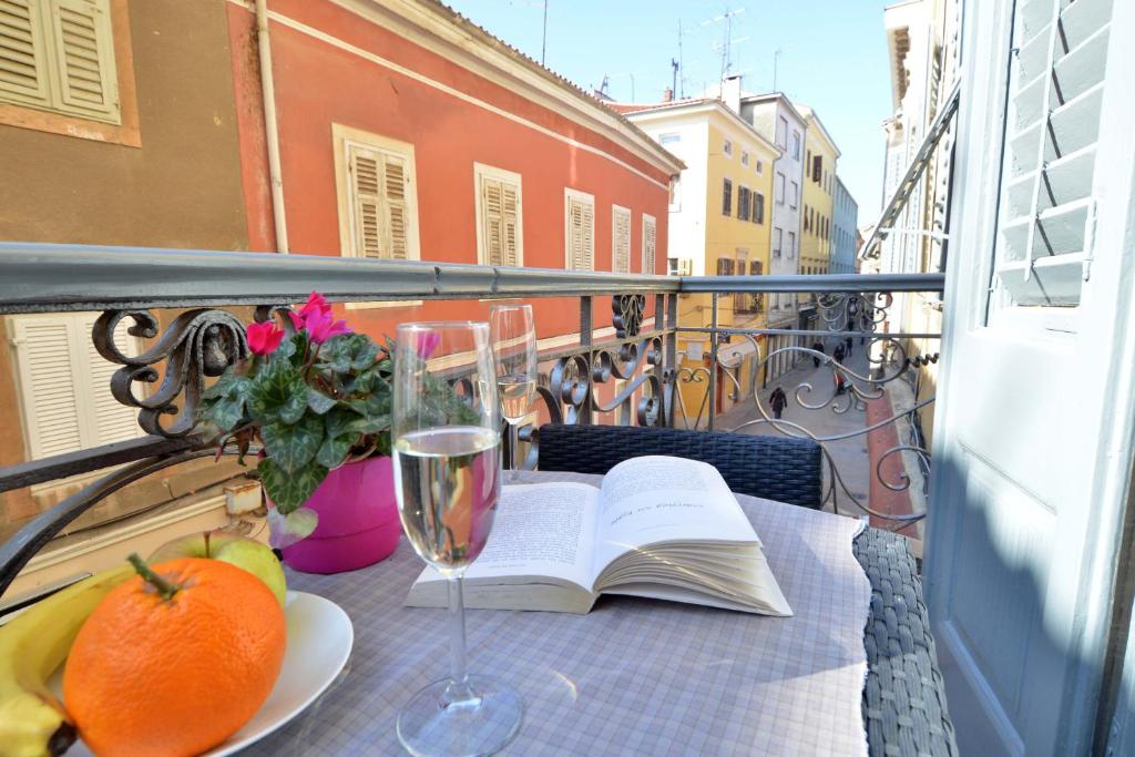 uma mesa com um livro aberto e um copo de vinho em Studio Burić em Pula