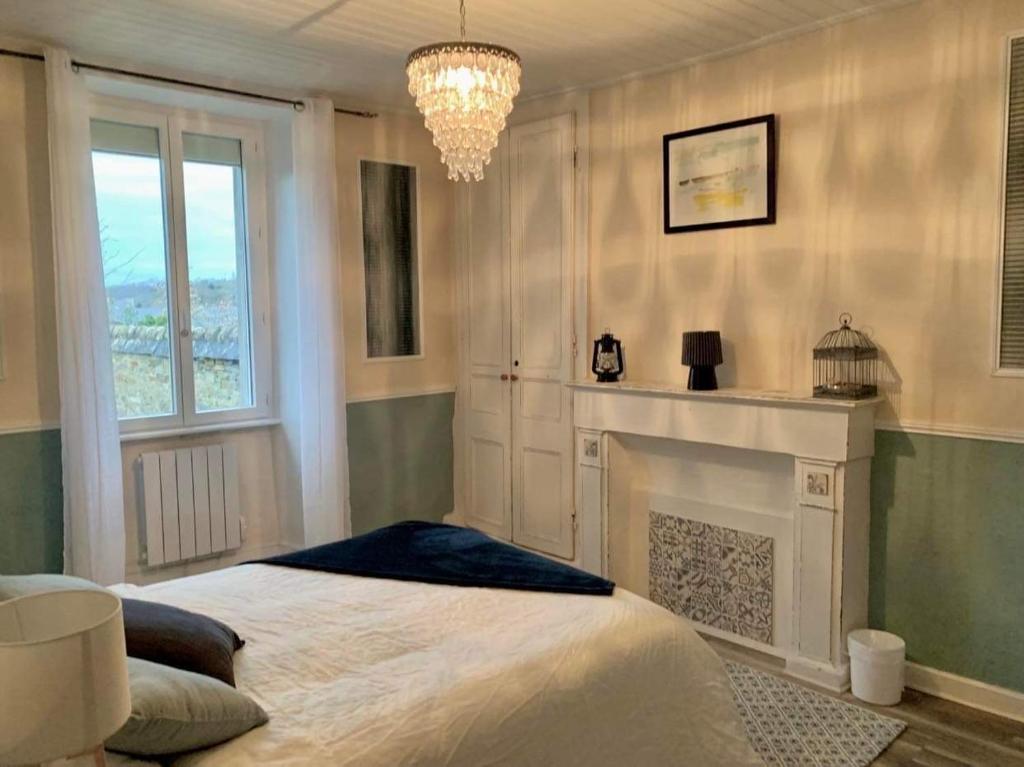 a bedroom with a bed with a fireplace and a chandelier at The LightHouse Chambres à louer in Châteaulin