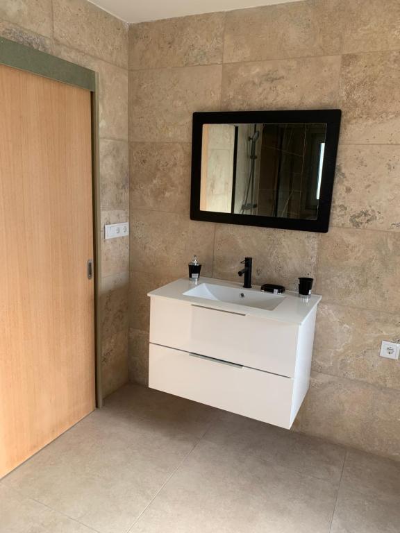 La salle de bains est pourvue d'un lavabo blanc et d'un miroir. dans l'établissement Casa Bella Vista, à Fafe