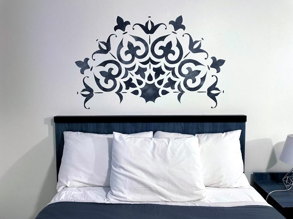 a bedroom with a bed with a black and white stenciled wall at Motel Moreau in Saint-Félicien