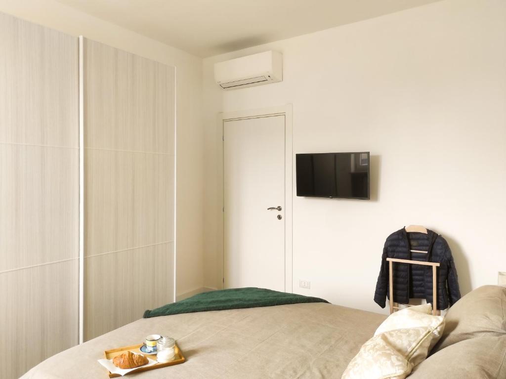 - une chambre avec un lit et une télévision murale dans l'établissement Primaticcio 6, à Milan