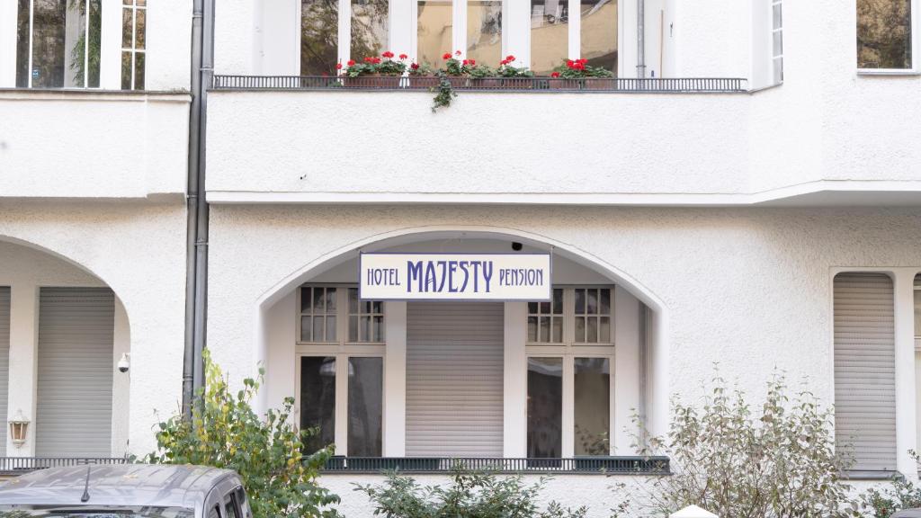 um edifício branco com um sinal que lê sala de mommainity em Pension Majesty em Berlim