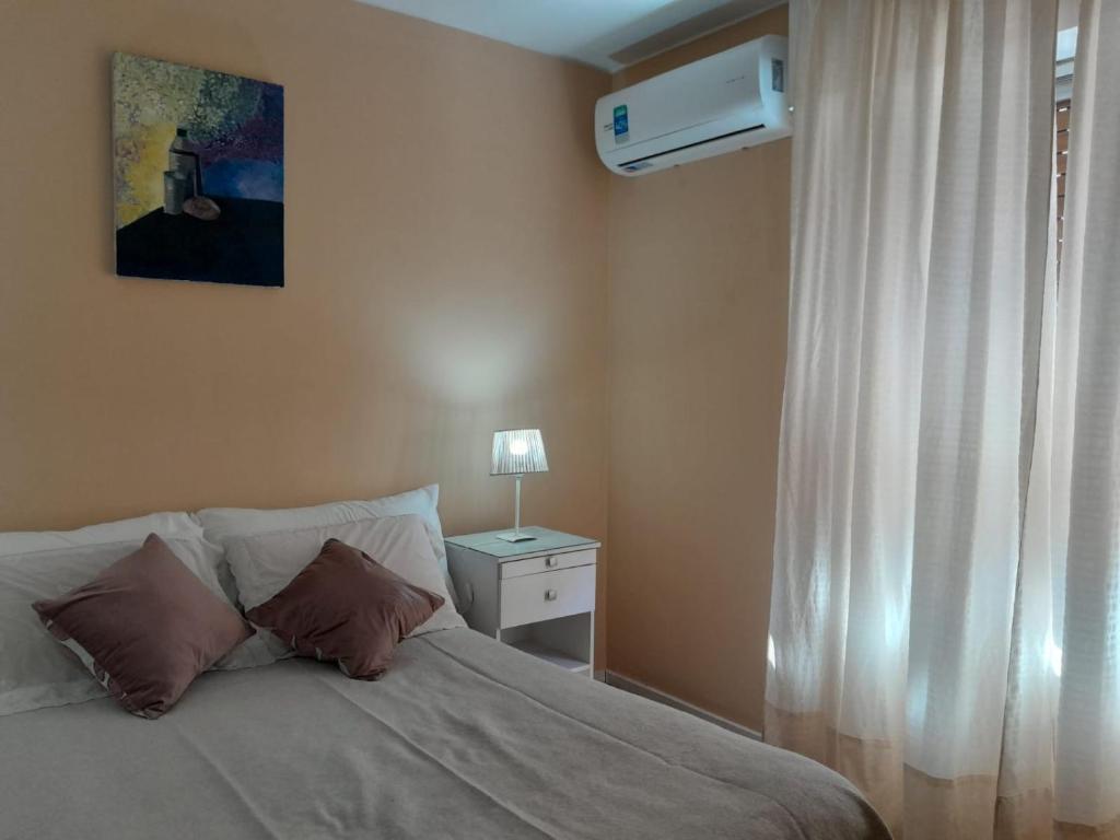 1 dormitorio con cama, ventana y lámpara en Departamento en el centro de Mendoza en Mendoza