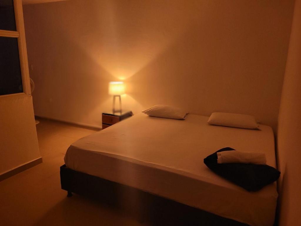 1 dormitorio con 1 cama grande y lámpara. en BOUTIQUE REAL, en Barrancabermeja