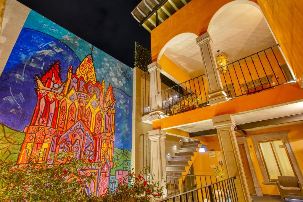 um grande mural no lado de um edifício com escadas em El Secreto em San Miguel de Allende