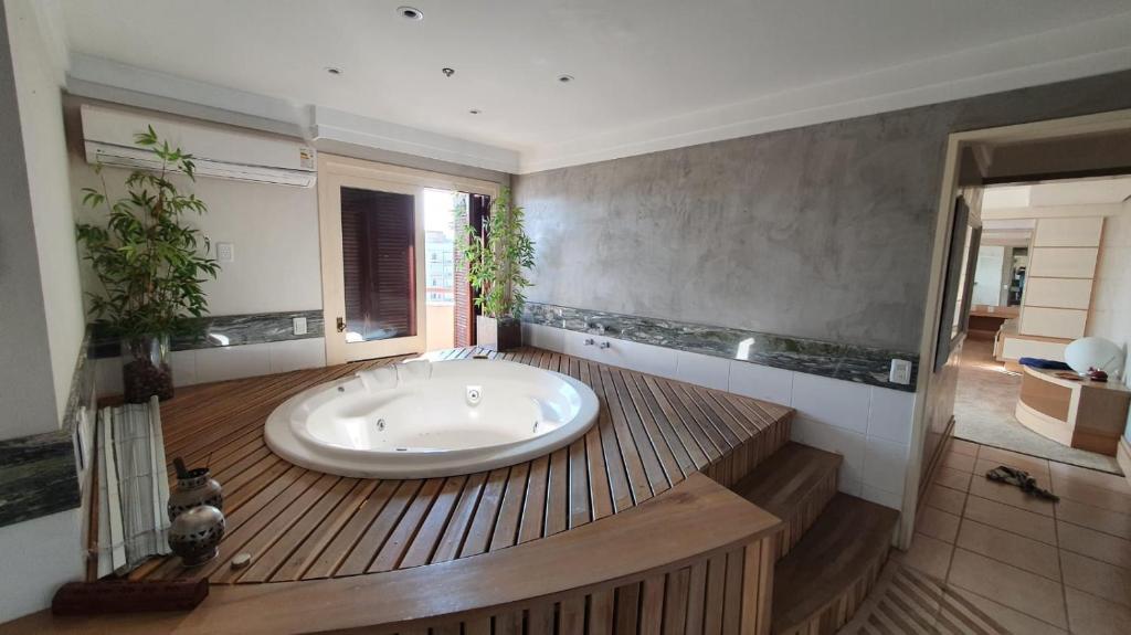 a large bathroom with a large tub in the middle at Flat Independência in Porto Alegre