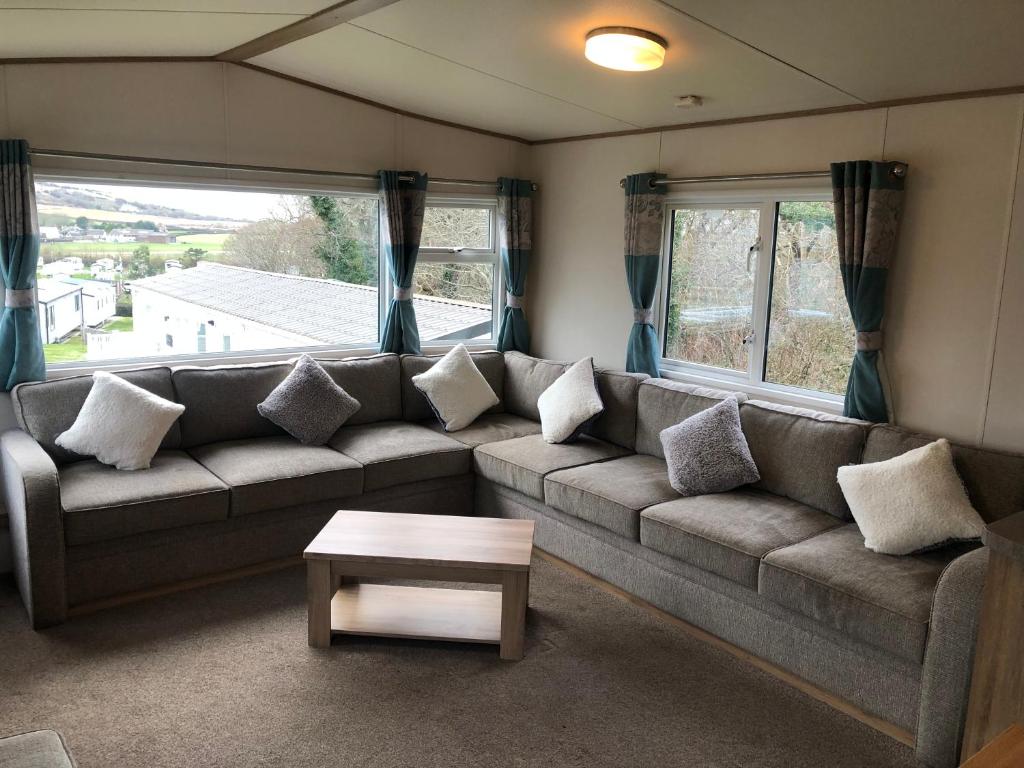 uma sala de estar com um sofá e uma mesa em Classy caravan with ample space em Bembridge