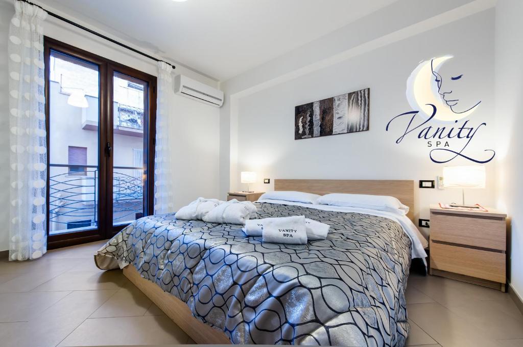 1 dormitorio con 1 cama y un cartel en la pared en Vanity SPA, en Balestrate