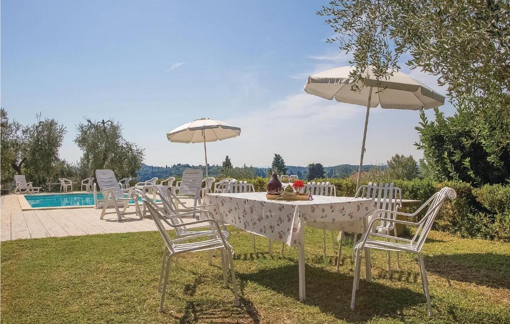 stół z krzesłami i parasolami przy basenie w obiekcie Nice Apartment In Marti Pi With Wifi w mieście Marti