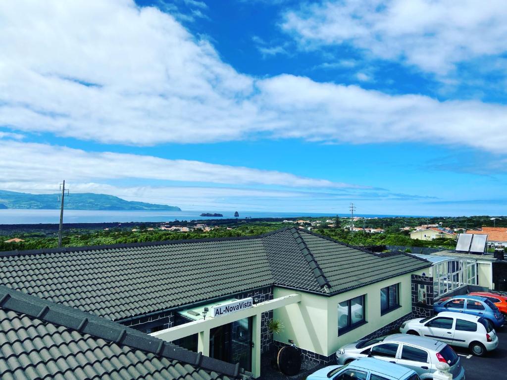 a view of a building with cars parked in a parking lot at Novavista - INN PICO in Criação Velha