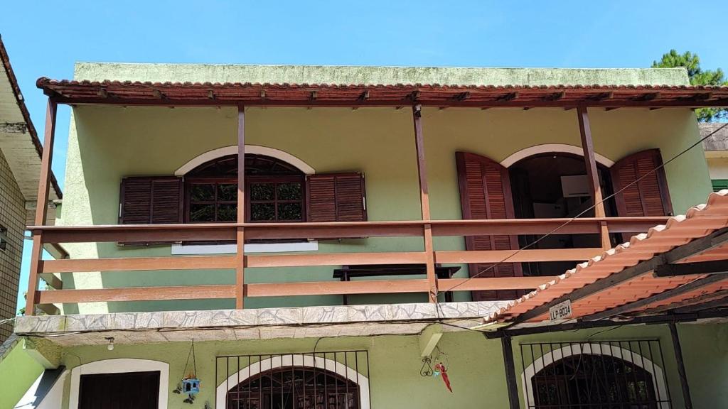 a building with brown shutters on the side of it at Hospedagem El Camino Del Viento in Teresópolis