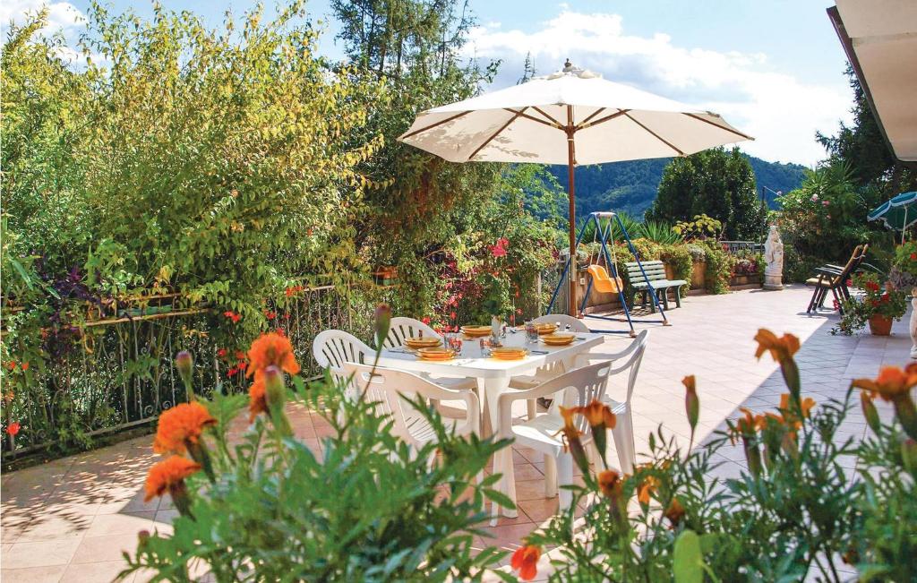 un tavolo bianco con ombrellone in giardino di Holiday Home Locmansana,Il Ceppo a Montemagno