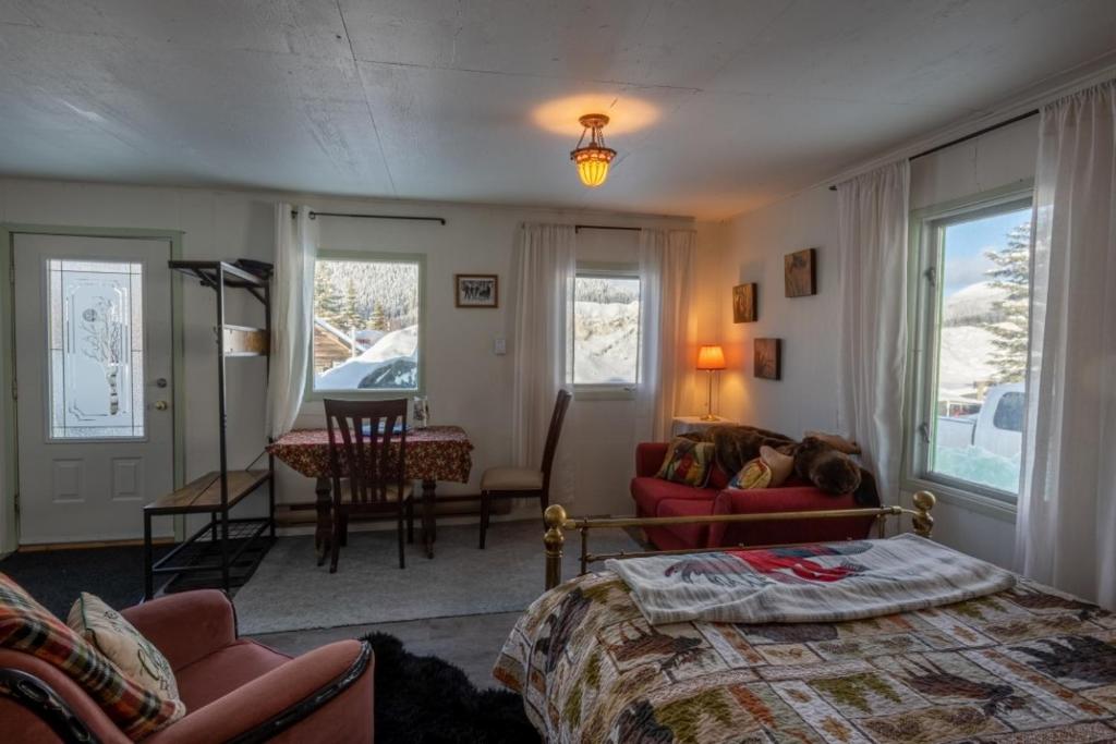 1 dormitorio con 1 cama y sala de estar en Meadow Suites in Wells, en Barkerville