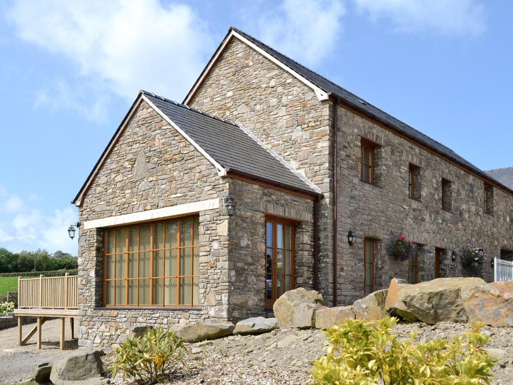 a large stone building with a bench in front of it at The Mill - Om3 in Mydroilin