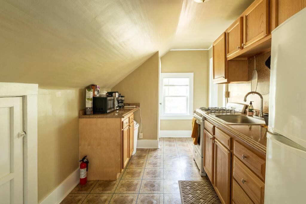Una pequeña cocina con gabinetes de madera y un fregadero. en Artist retreat near all Rochester sites, en Rochester