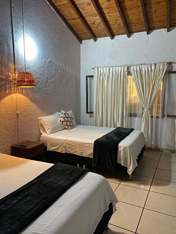 聖吉爾的住宿－THIS IS COLOMBIA HOSTEL，酒店客房设有两张床和窗户。