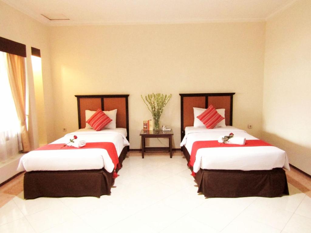Postel nebo postele na pokoji v ubytování Hotel Pelangi Malang, Kayutangan Heritage