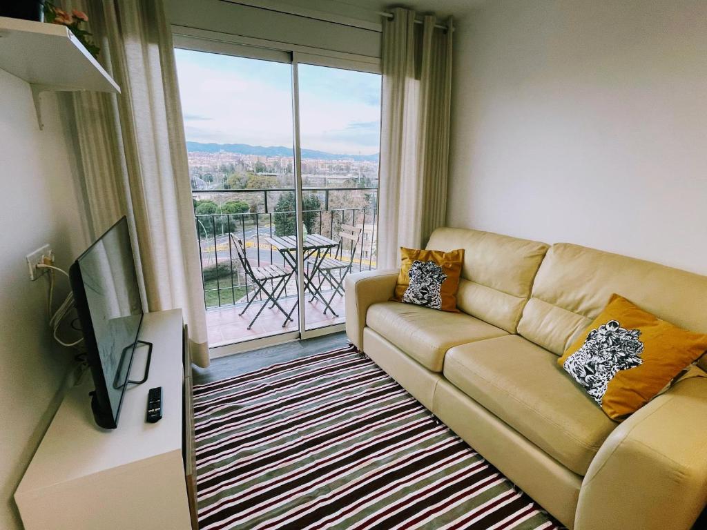 a living room with a couch and a large window at Magnifico Apartamento Barca 4 in Barcelona