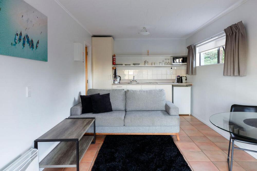 a living room with a couch and a table at Unit 1 Kaiteri Apartments and Holiday Homes in Kaiteriteri