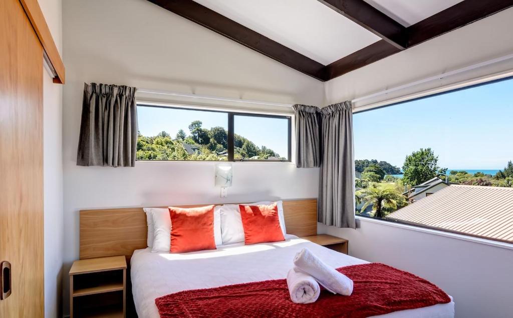 a bedroom with a bed and a large window at Unit 3 Kaiteri Apartments and Holiday Homes in Kaiteriteri