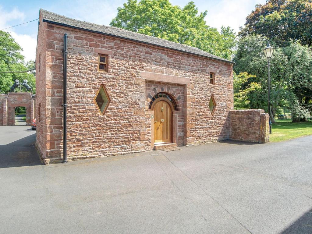 an old brick building with a wooden door at Corby Castle - Diamond Cottage - Uk34668 in Great Corby
