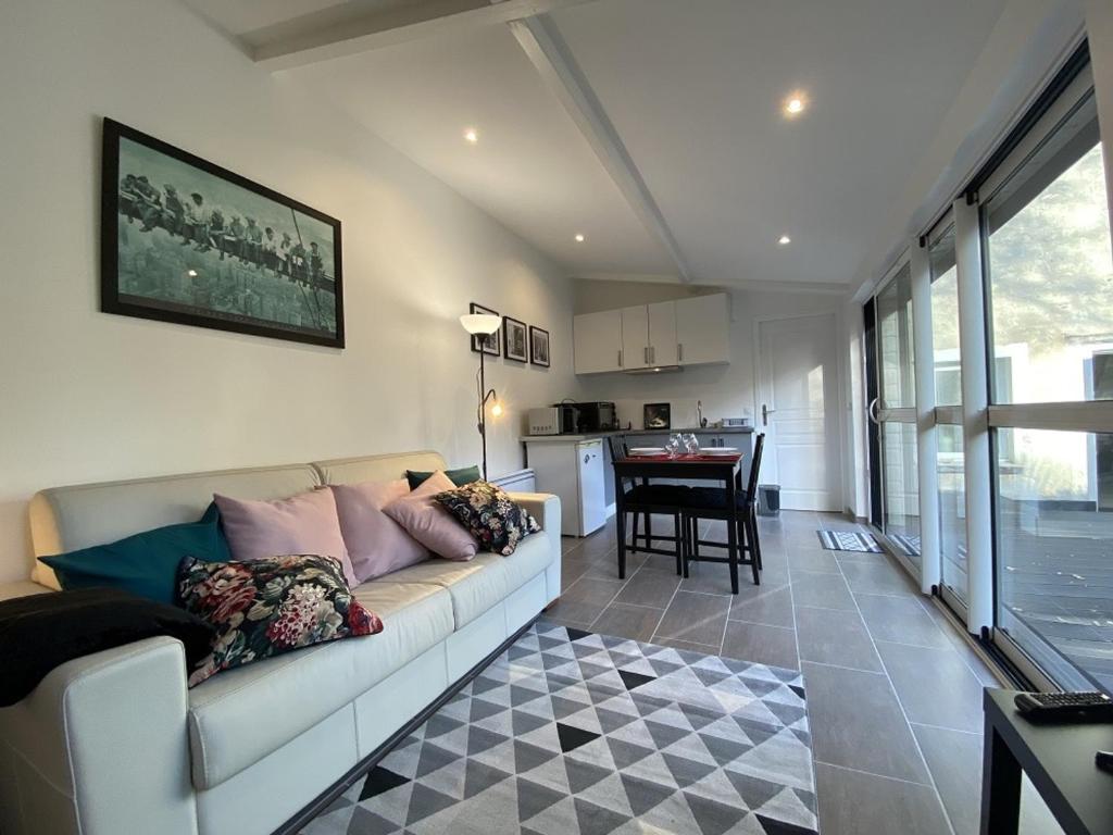 un salon avec un canapé blanc et une table dans l'établissement Studio lumineux avec jardin privé et terrasse en plein centre de La Roche-Posay - FR-1-541-96, à La Roche-Posay