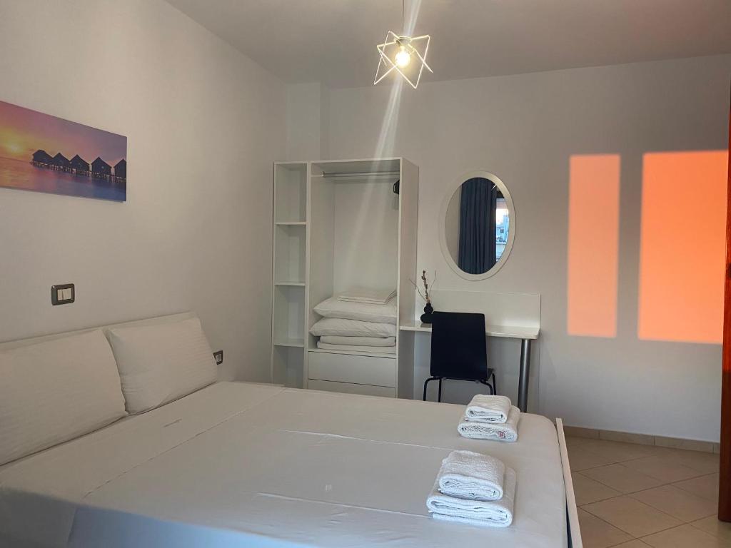 a bedroom with a white bed and a desk at Villa White in Ksamil