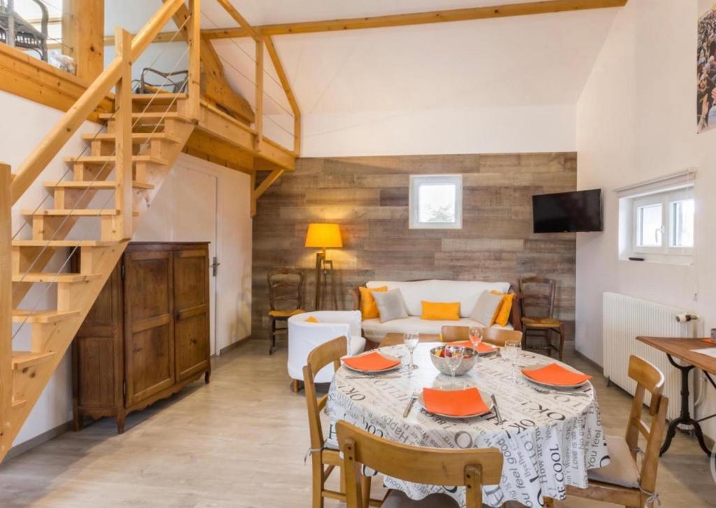 a living room with a table and a staircase at Canadian Beach Hut in Bénerville-sur-Mer