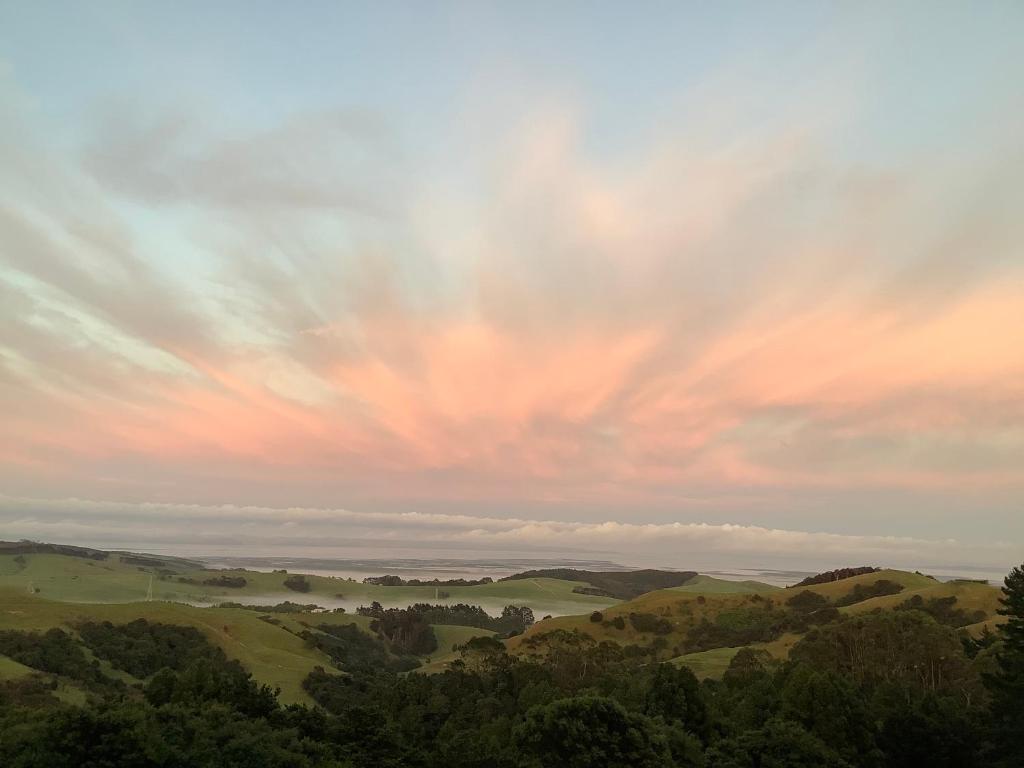 een bewolkte hemel met uitzicht op de heuvels bij Kaipara Views Eco Lodge in Glorit