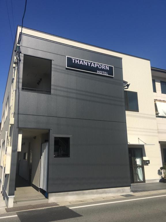 un edificio con un letrero que lee el hospital Therapyatown en Thanyaporn Hotel, en Takayama