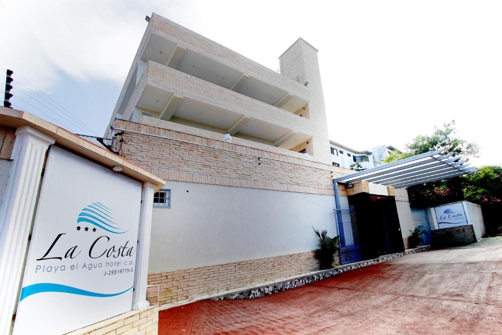 a building with a sign on the side of it at La Costa Playa El Agua Hotel in El Agua