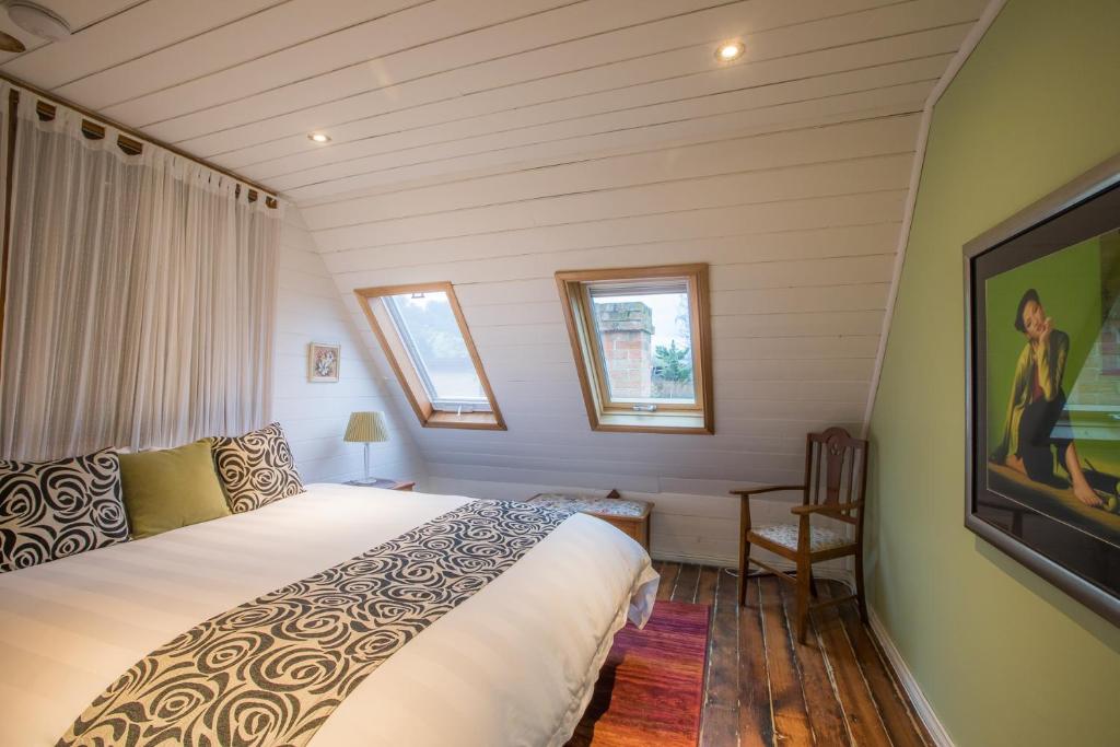 a bedroom with a large bed and a tv at Abbey on Main - Unique heritage listed property overlooking the Huon River in Franklin
