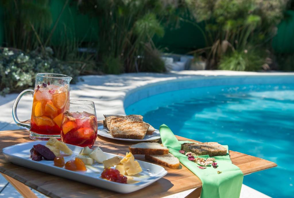 una bandeja de comida en una mesa junto a una piscina en Aguará Hotel & Spa en Lobos