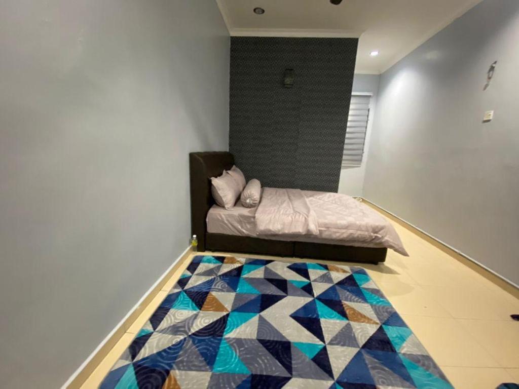 a bedroom with a bed and a quilt on the floor at My Pool House in Alor Setar