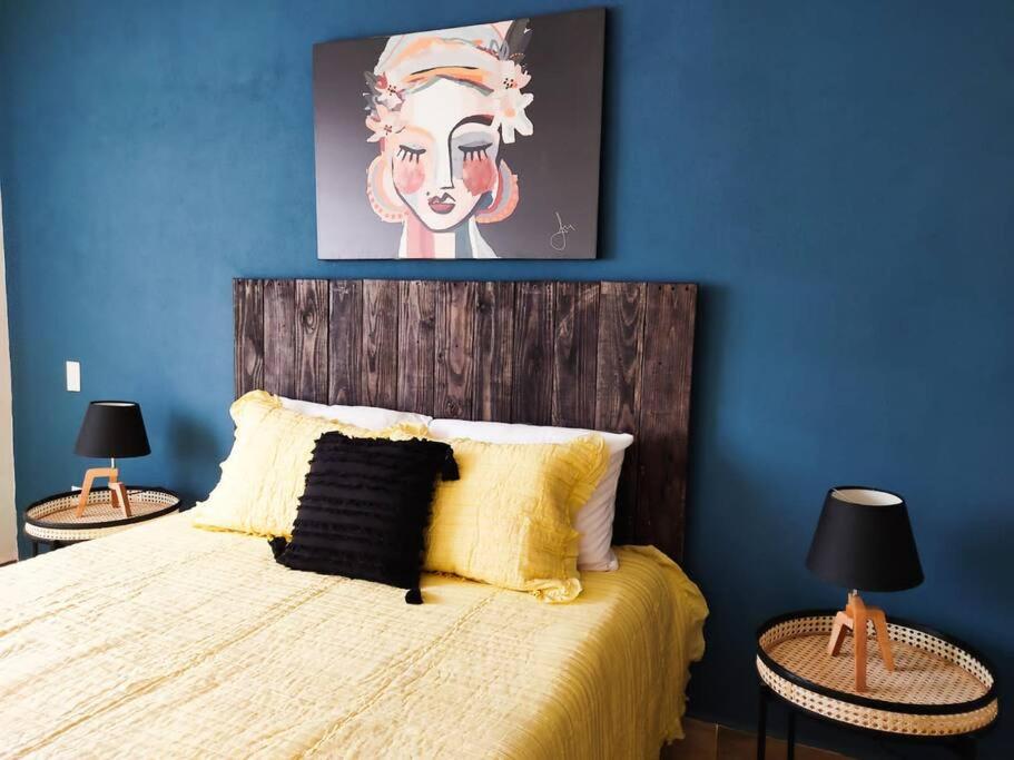 um quarto com uma cama com uma parede azul em Hermosa casa para conocer León em León