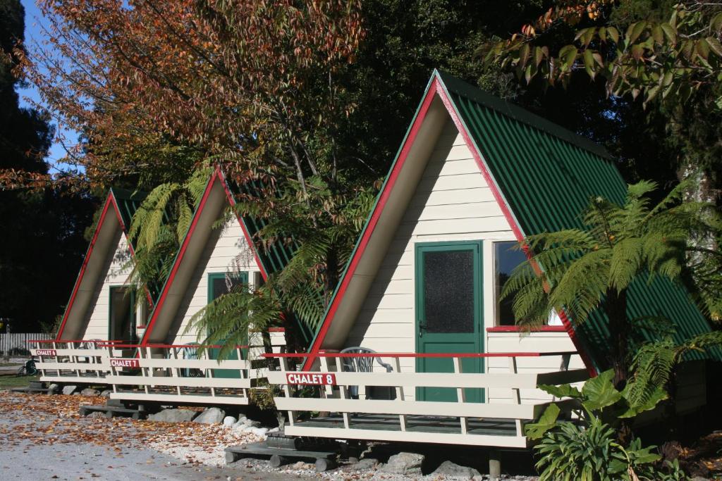 una fila de cabañas con techos rojos y verdes en Westport Kiwi Holiday Park & Motels, en Westport