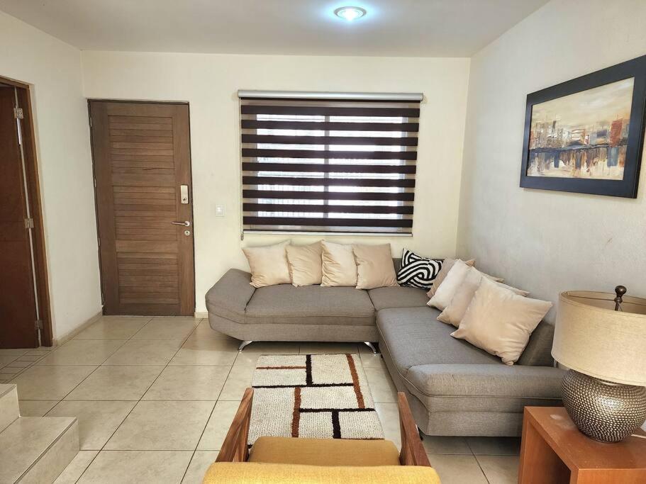 uma sala de estar com um sofá e uma janela em Casa para grupos grandes por el ITESO em Guadalajara