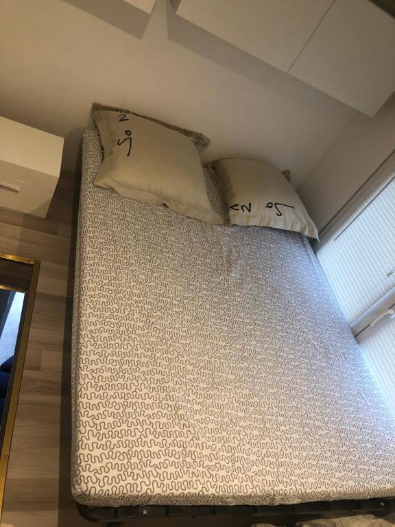 een bed in een kamer met twee kussens erop bij Studio indépendant avec terrasse-climatisation in Marseille