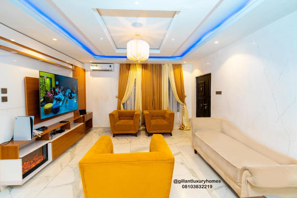 Gillant Luxury Homes في بنين سيتي: غرفة معيشة مع أريكة وتلفزيون
