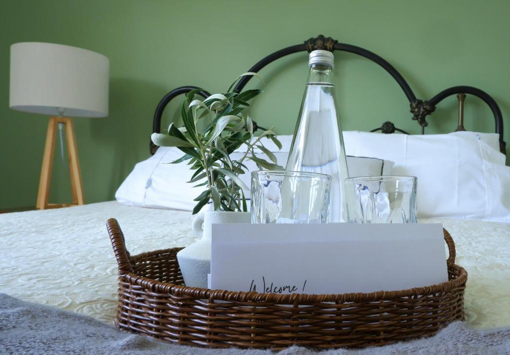 a basket with a bottle of wine and glasses on a bed at Vines on Bannockburn in Cromwell