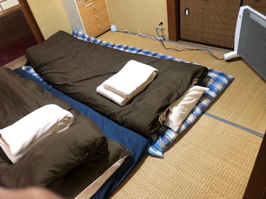 una camera con due letti con asciugamani di 桃源郷２ a Toba