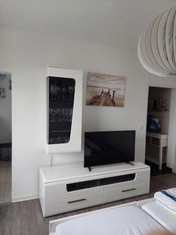 ein weißes Wohnzimmer mit einem Flachbild-TV in der Unterkunft Wohlfühlort in Zwenkau