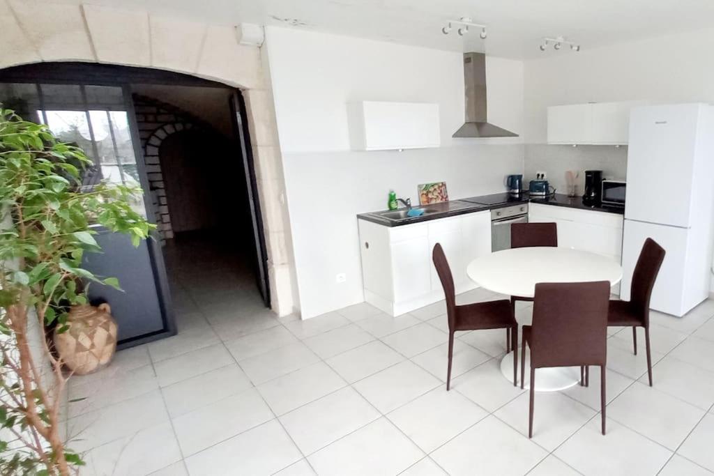 une cuisine avec une table et des chaises dans une cuisine dans l'établissement Le Nid - Amboise gîte semi troglodyte, à Amboise