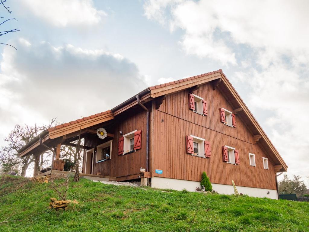 a house on a hill with red shuttered windows at Le Chalet au vieux vignoble avec espace Sauna et Jacuzzi in Bouxwiller